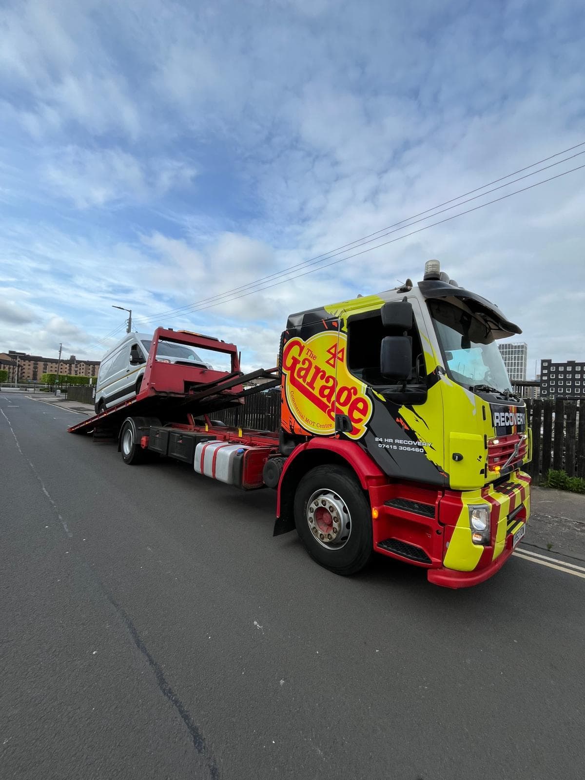 Flatbed recovery truck transporting a car